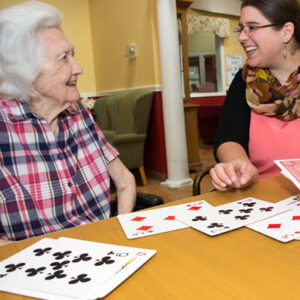 Vermont dementia care facility member plays cards with staff