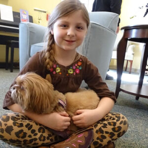 Child holds dog at Windsor retirement community