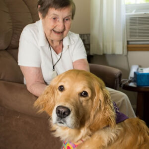 Resident at Vermont dementia care center sits with adorable dog