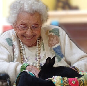 Vermont dementia care resident enjoying time with a furry friend