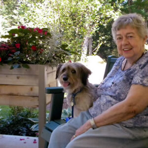 Resident smiles with dog at assisted living care in Windsor