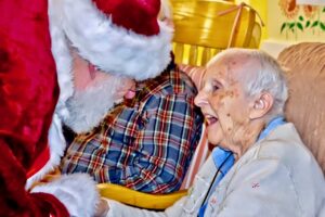 A resident is thrilled to see Santa at the Holiday Open House